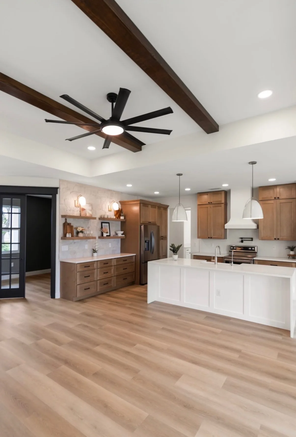 Open kitchen with custom cabinetry, island, and wood beams